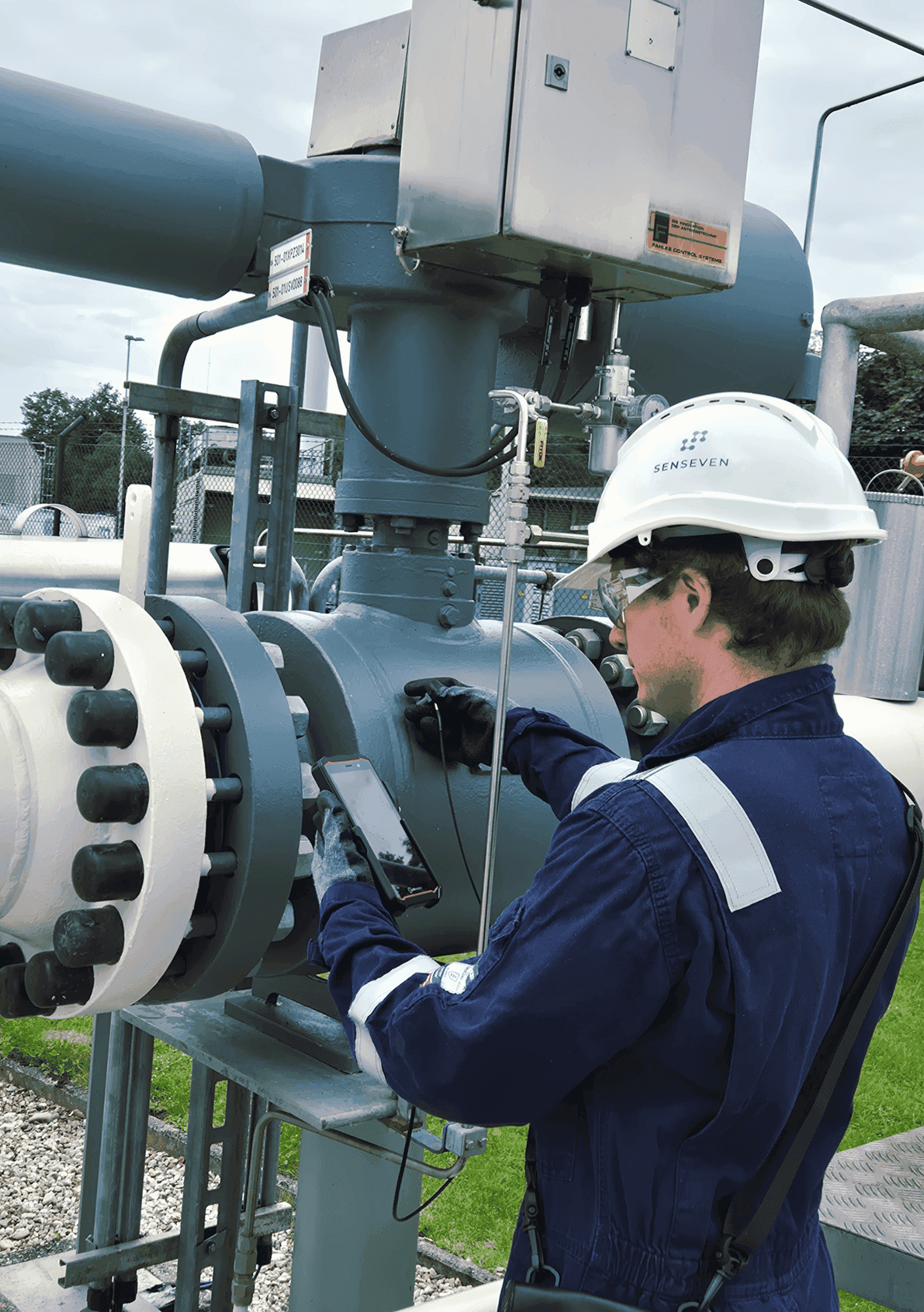 Michael Hettegger inspecting a control valve with the Valve Sense sensor and smartphone